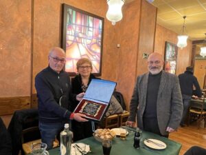 Entrega de placa conmemorativa durante un acto de reconocimiento entre miembros del equipo de Overtel