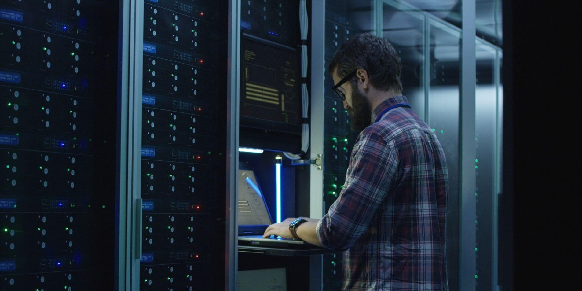 Técnico informático gestionando servidores en un centro de datos.