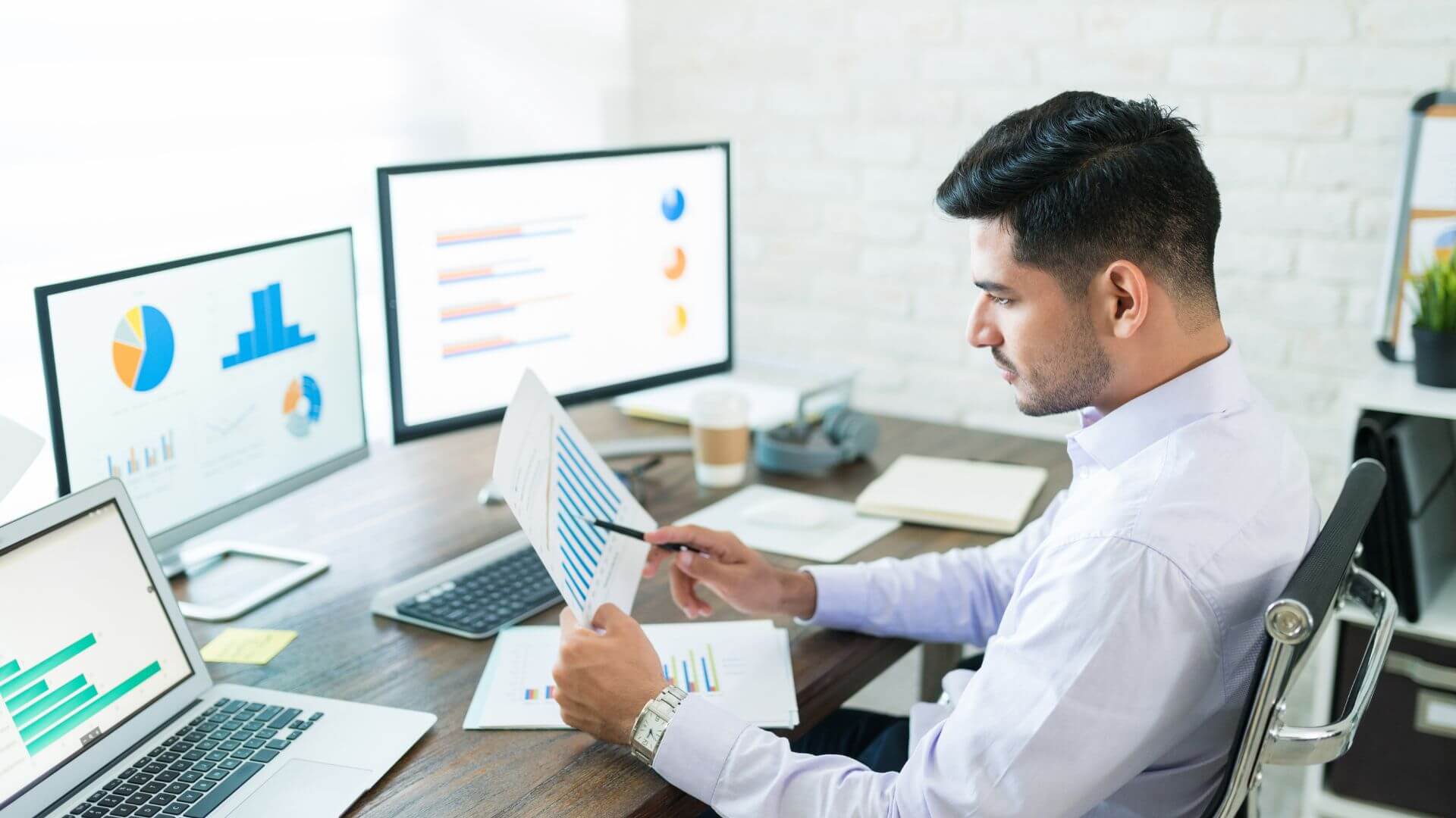 Director de operaciones analizando informes de OEE y KPIs de producción en pantallas, ejemplo de control de manufactura sin software MES en tiempo real.