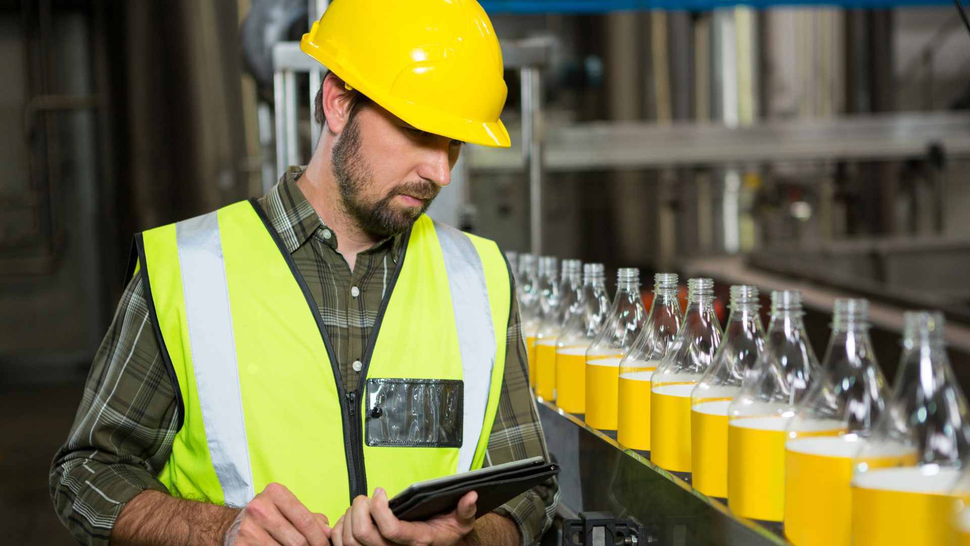 Operario con tablet en linea de envases plásticos