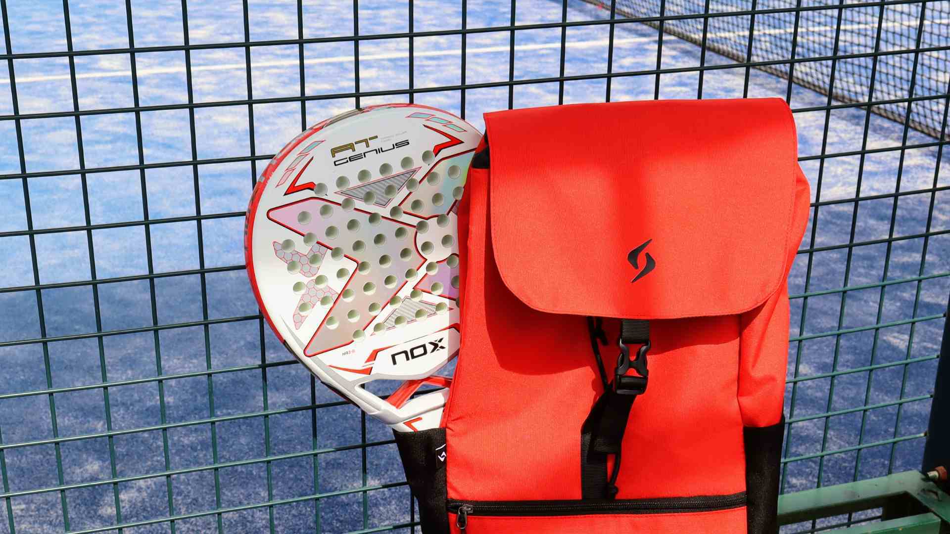 Pala de pádel y mochila junto a la red de una pista para ilustrar la metáfora de leer toda la pista en planta industrial.