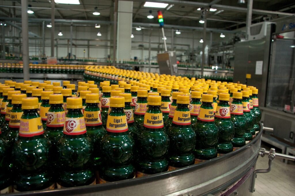 Botellas en línea de producción automatizada en una planta de la industria alimentaria.
