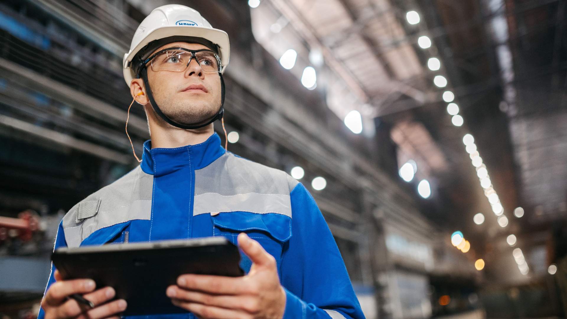 Operario industrial consultando trazabilidad y costes por lote en tablet en planta de PYME manufacturera.
