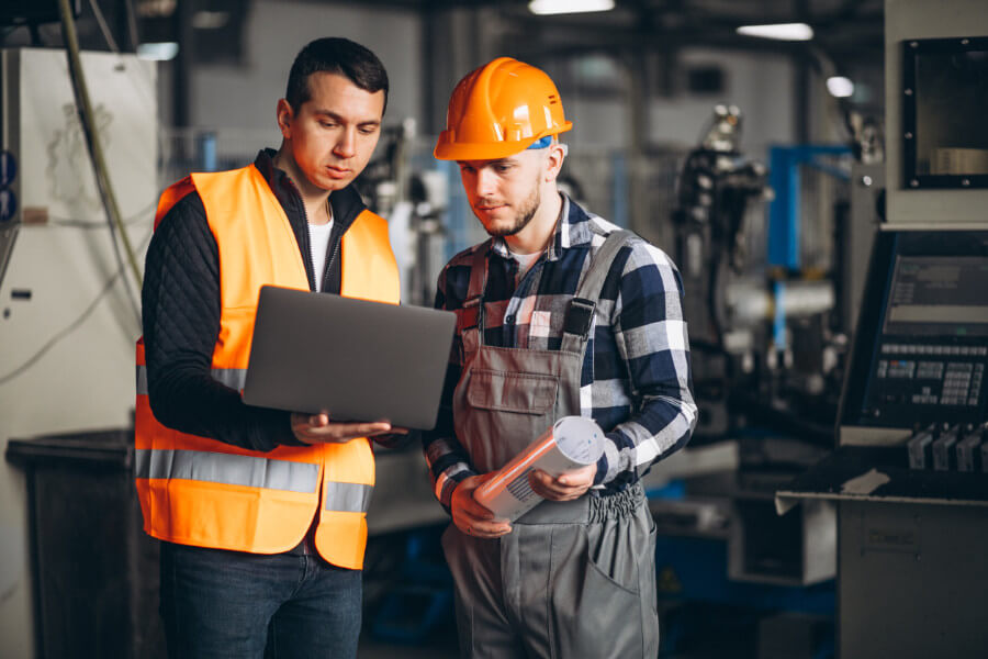 Operarios observando un ordenador en un entorno industrial