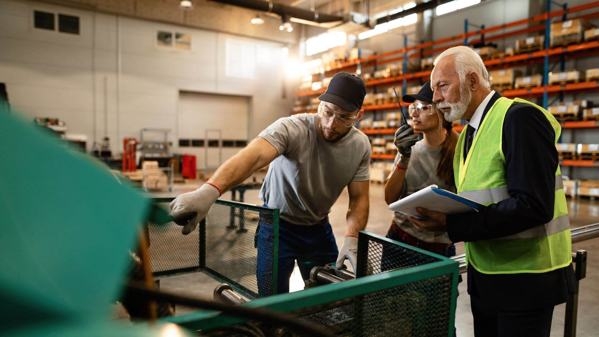 Director de operaciones y operarios revisando maquinaria en planta industrial, señal de fábrica ineficiente sin software MES ni control de producción.