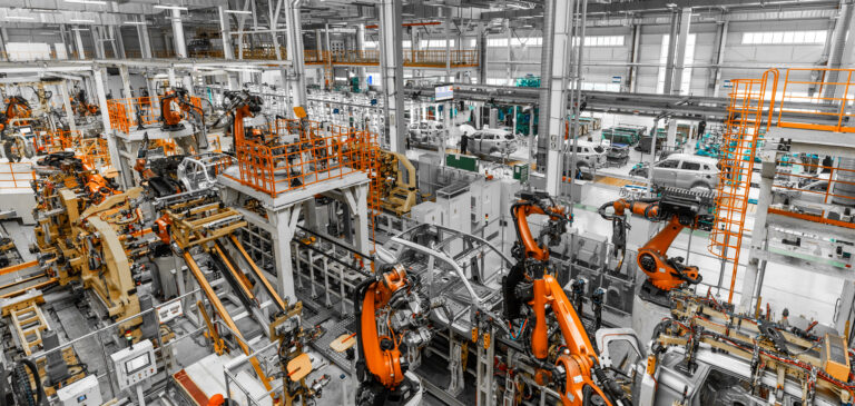 Línea de producción automatizada con brazos robóticos.