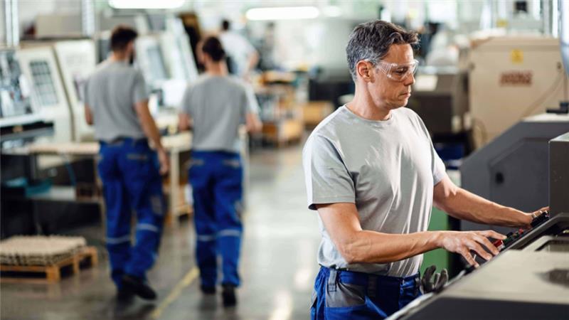 trabajador-adulto-medio-que-opera-maquina-cnc-mientras-trabaja-instalacion-industrial