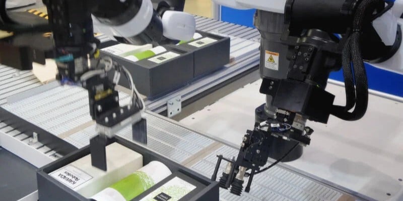 Brazos robóticos automatizando tareas de manipulación en una línea de producción industrial