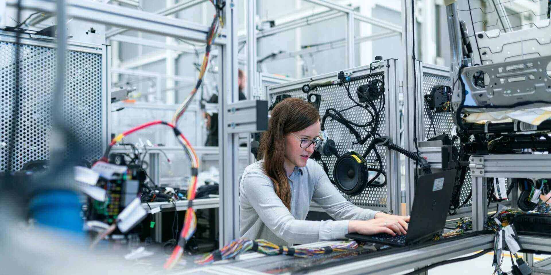 Ingeniera supervisando procesos industriales con software ERP.