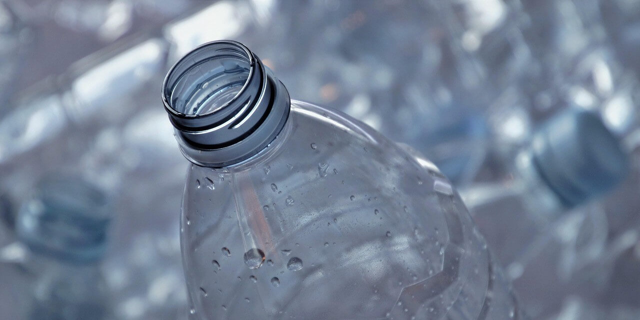Botella de plástico transparente con gotas de agua