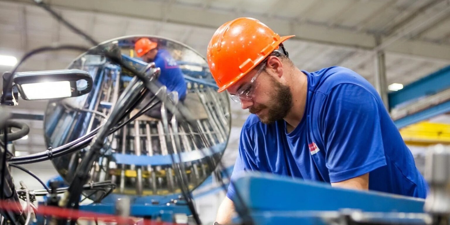 Trabajador operando maquinaria en una planta de manufactura industrial